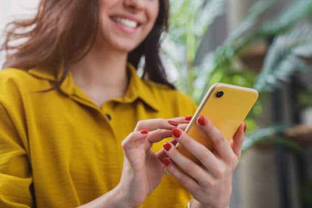 Woman smiling looking down at her phone 