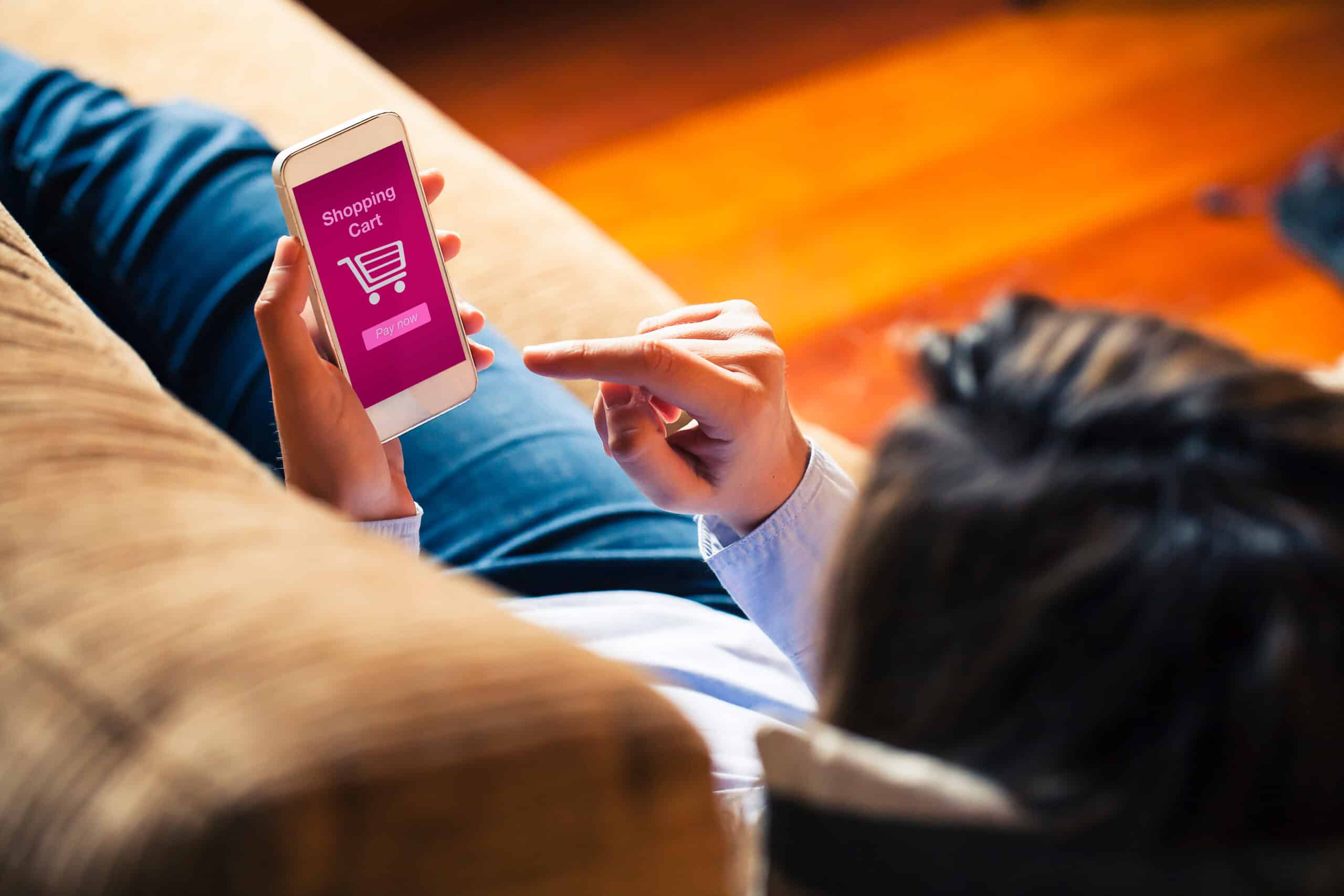 Woman shopping by mobile phone laying at home