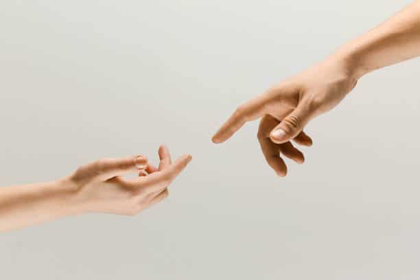 Moment of weightless. Two male hands trying to touch like a creation of Adam sign isolated on grey studio background. Concept of human relation, community, togetherness, symbolism, culture and history.