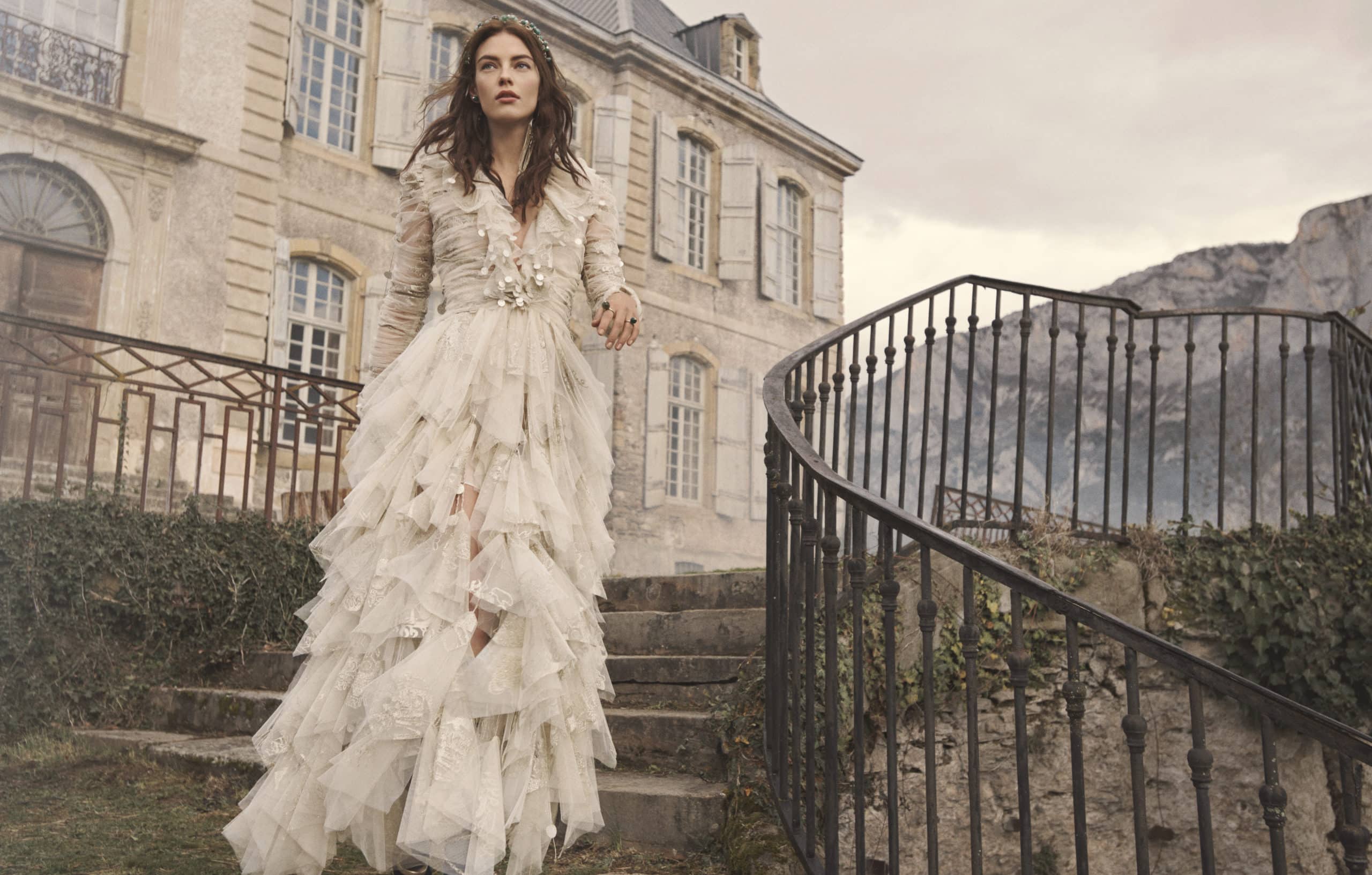 Woman in white Zimmermann dress walking down stairs outside