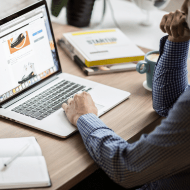 man online shopping for shoes at desk.