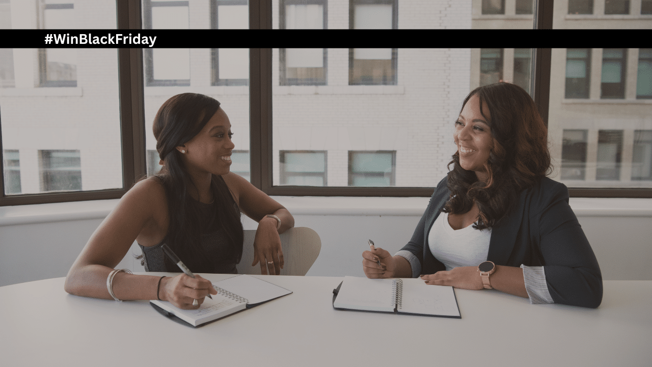 #WInBlackFriday two women talking at a conference table