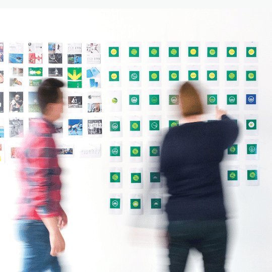 2 people brainstorming with sticky notes on a wall